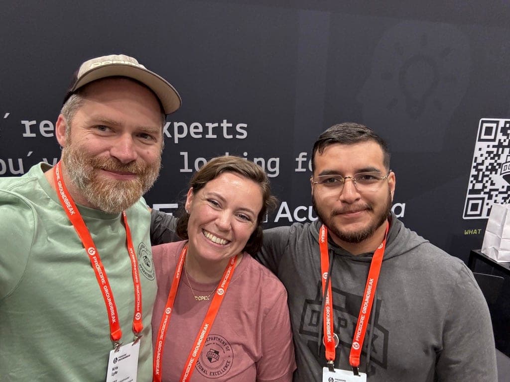 Tres integrantes del equipo de DOPEX sonriendo en el stand de DOPEX en Procore Groundbreak 2026